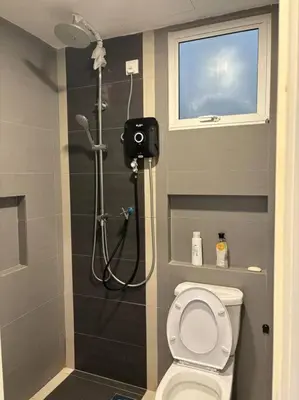 a bathroom with a shower with a toilet and a camera at KF Homestay Deluxe Suite in Kampar
