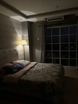 a bedroom with a bed and a window at night at KF Homestay Deluxe Suite in Kampar