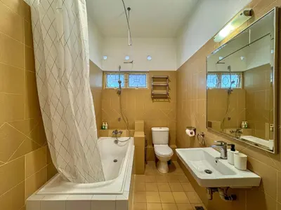 a bathroom with a tub and a toilet and a sink at PRIME Location - 5 Mins Walk to Shops & Eateries! in Tanjung Bungah