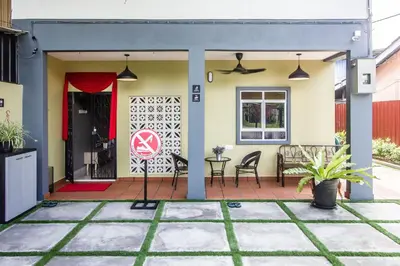 a home with a patio with a table and chairs at Plumeria 4BR Garden House by uBook in Butterworth