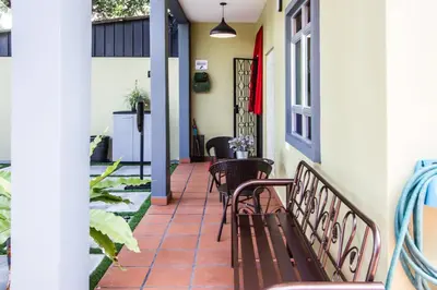 a porch with two benches and a table at Plumeria 4BR Garden House by uBook in Butterworth