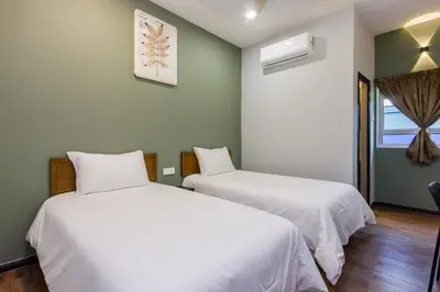 two beds in a room with green walls at Heaven 5BR Garden Inn by uBook in Butterworth