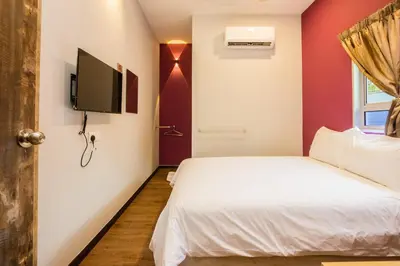 a bedroom with a bed and a tv on a wall at Great 5BR Garden Inn by uBook in Butterworth