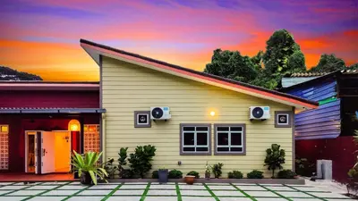 a small house with a sunset in the background at Great 5BR Garden Inn by uBook in Butterworth