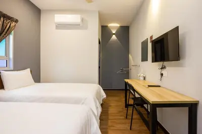 a bedroom with two beds and a desk and a tv at Great 5BR Garden Inn by uBook in Butterworth