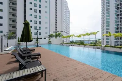 a swimming pool in a building with chairs and an umbrella at Purrfect Nook 1BR Georgetown Straits Garden \u4e00\u623f\u4e00\u5385\u5f0f in Jelutong