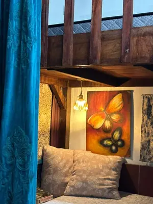 a painting of a butterfly is on the wall above a bed at Husna homestay in Sungai Besar