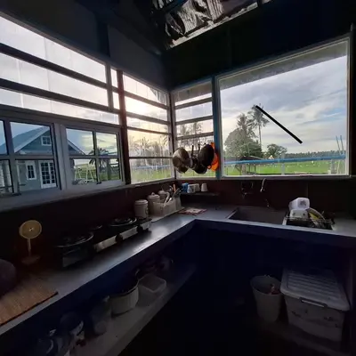 a person standing in a kitchen looking in the window at Husna homestay in Sungai Besar