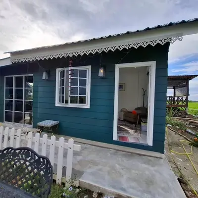 a blue house with a white fence in front of it at Husna homestay in Sungai Besar