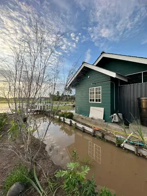 a house is surrounded by water in front of it at Husna homestay in Sungai Besar