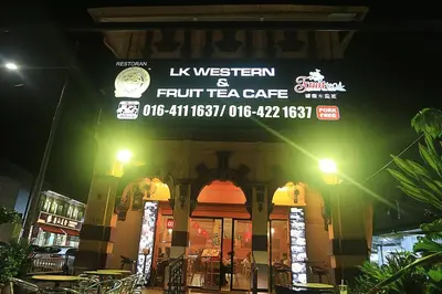 a building with a sign for a fruit tea cafe at night at Seaview Sunrise 1BR at Tropicana 218 at Central Location & Food Hunt Friendly in George Town