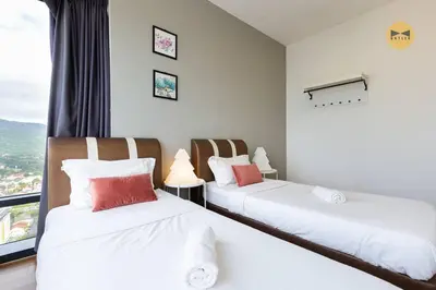 two beds in a room with a window at Spacious 3BR in Tropicana 218 at Central Location & Food Hunt Friendly in George Town
