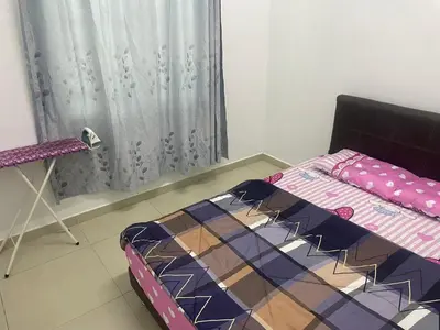 a bed sitting in a room with a curtain at Homestay Cactus Apparment in Brinchang