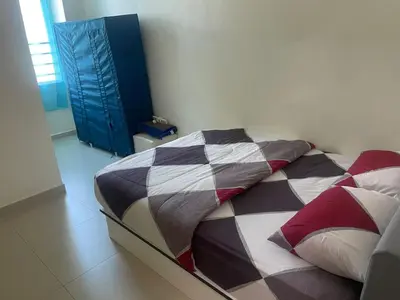 a bed with a colorful comforter in a room at Homestay Cactus Apparment in Brinchang