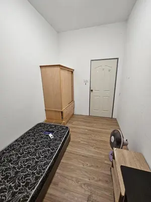 an empty room with a bed and a closet at Amoy Lane Hostel Penang in George Town