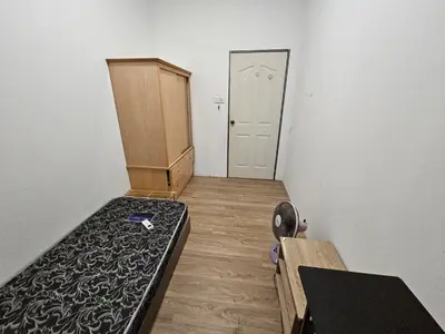 an empty room with a bed and a door at Amoy Lane Hostel Penang in George Town