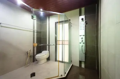 a bathroom with a toilet and a glass shower at Bukit Mertajam Double Storey Bungalow 15pax BBQ KTV in Bukit Mertajam