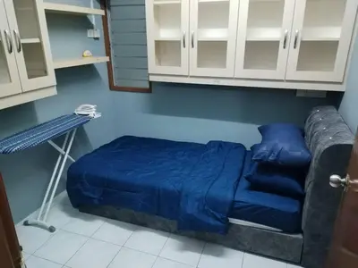 a room with a blue bed and a couch at Amara Homestay Cameron Highlands in Cameron Highlands