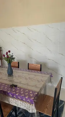 a dining room table with a vase of flowers on it at Homestay Cikgu Siti teluk intan in Teluk Intan