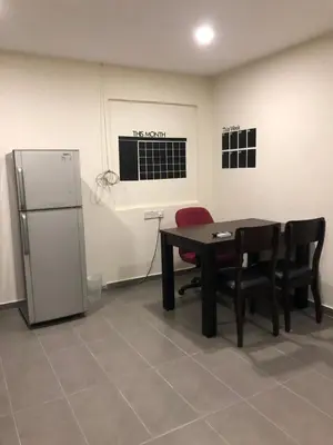 a room with a table and chairs and a refrigerator at Ipoh Budget in Ipoh