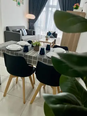 a dining table and chairs in a living room at Anderson Ipoh by Iconique Espace in Ipoh