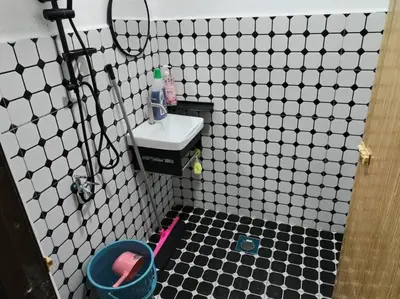 a bathroom with a black and white tiled floor and a sink at Anggerik Homestay suasana kampung in Kampong Batu Dua Puloh Tiga