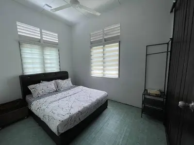 a bedroom with a bed and two windows at Anggerik Homestay suasana kampung in Kampong Batu Dua Puloh Tiga