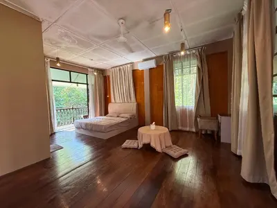 a room with a bed and a table in it at Villa Kuala Woh Resort in Tapah
