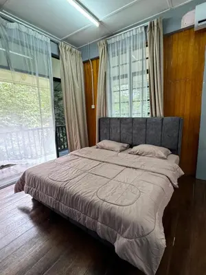 a bedroom with a large bed with a large window at Villa Kuala Woh Resort in Tapah