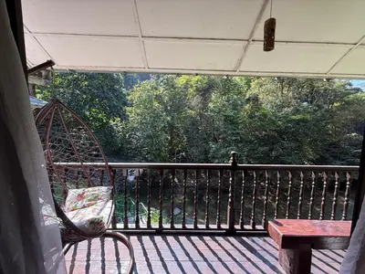 a porch with a swing and a bench on a balcony at Villa Kuala Woh Resort in Tapah
