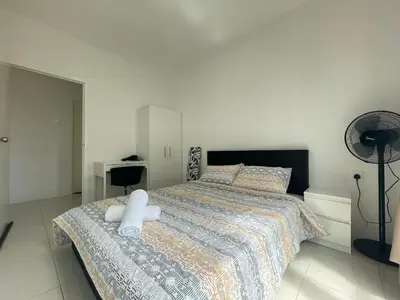 a bedroom with a bed with white sheets and a desk at Ipoh Town Centre The Anderson For 5pax in Ipoh
