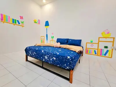 a bedroom with a bed in a room with paintings at GOLDEN HOUSE ,1min to aeon, 7min to zoo,8min to lake gardens in Taiping