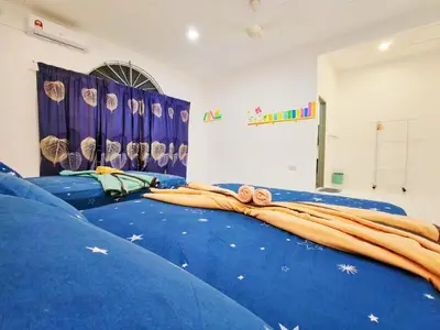 a room with two beds with blue sheets at GOLDEN HOUSE ,1min to aeon, 7min to zoo,8min to lake gardens in Taiping