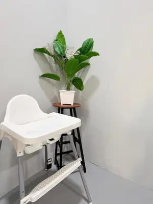 a white chair and a plant on a stool at KB Penang Guest House1-8pax in Kepala Batas