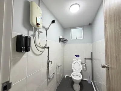 a bathroom with a toilet and a phone on the wall at KB Penang Guest House1-8pax in Kepala Batas