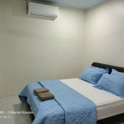 a bedroom with a bed with blue sheets and blue pillows at MKF Homestay Padang Stang, Gerik in Gerik