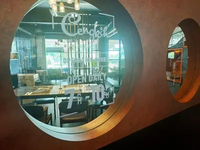 a mirror reflecting a restaurant with a dining room at Cinta Sayang Resort in Sungai Petani