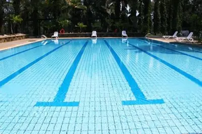 a large swimming pool with chairs in it at Cinta Sayang Resort in Sungai Petani