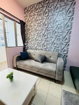 a living room with a couch against a wall at AYAAN SYMPHONY INN Budget Homestay with Free WiFi and Netflix in Tanah Rata