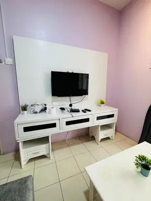 a living room with a tv on a white desk at AYAAN SYMPHONY INN Budget Homestay with Free WiFi and Netflix in Tanah Rata