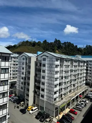 an apartment complex with cars parked in a parking lot at AYAAN SYMPHONY INN Budget Homestay with Free WiFi and Netflix in Tanah Rata