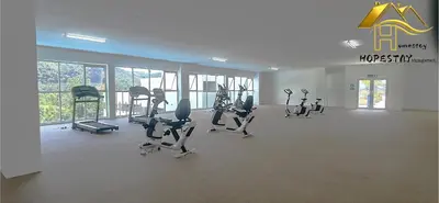 a gym with treadmills and ellipticals in a room with windows at Ipoh Town 2224 six pax By Hopestay in Ipoh