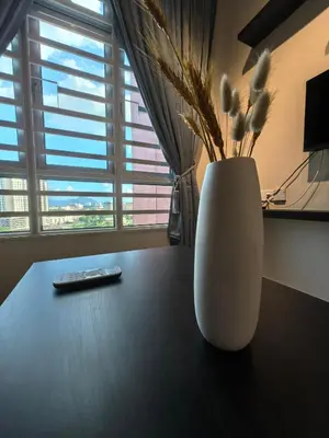 a white vase sitting on a table with a remote control at Ipoh Town 2224 six pax By Hopestay in Ipoh