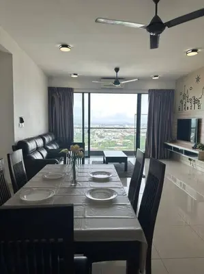 a dining room with a table with chairs and a couch at SweeT Homestay in Perai