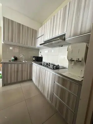 a kitchen with wooden cabinets and a counter top at SweeT Homestay in Perai
