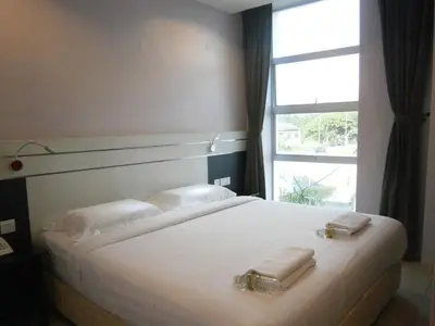 a bedroom with a bed with two towels on it at Hotel Kawan in Tapah