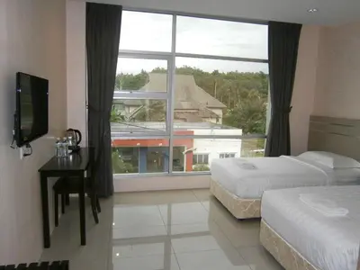 a bedroom with two beds and a large window at Hotel Kawan in Tapah