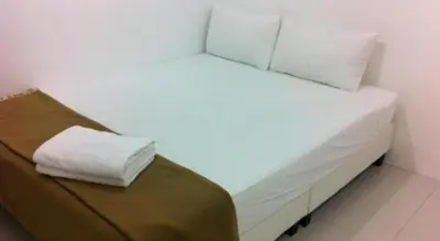a white bed with two pillows on it in a room at Chin Yee Hotel in Teluk Intan