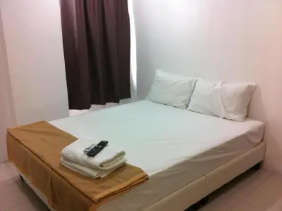 a bed with a remote control sitting on top of it at Chin Yee Hotel in Teluk Intan