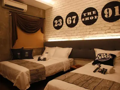 two beds in a hotel room with signs on the wall at The Shop Hotel in Kuala Kangsar